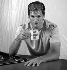 black and white photograph of a man with paint on his face holding a coffee mug