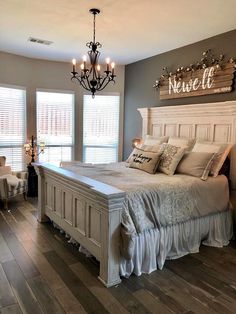 a large bed sitting inside of a bedroom on top of a hard wood floor