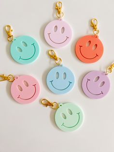 four key chains with smiley faces on them