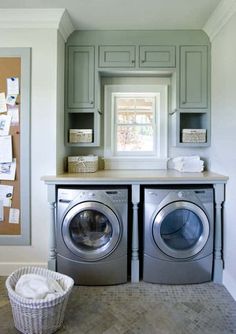 a washer and dryer in a laundry room next to a window with pictures on the wall