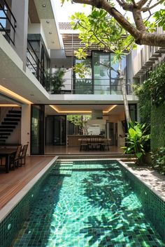 an indoor swimming pool in the middle of a house with stairs leading up to it