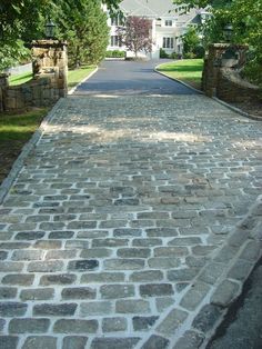 a brick walkway leading to a large white house