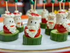 some food is sitting on a plate with toothpicks in the shape of santa claus