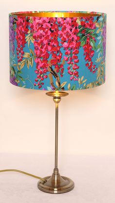 a lamp that has flowers on it and a blue lampshade with gold trim