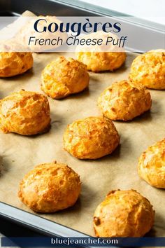 baked cheese puffs on a baking sheet with text overlay that reads gougeres french cheese puff