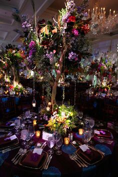 the table is set with flowers, candles and place settings for guests to sit at