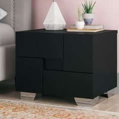 a nightstand with a plant on top of it in front of a pink bedroom wall