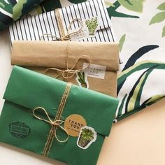 three wrapped presents sitting next to each other on top of a white and green table cloth