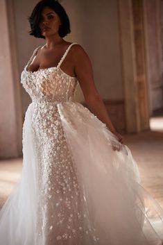 a woman in a wedding dress posing for the camera