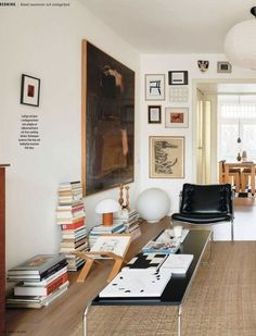 a living room filled with lots of furniture and pictures on the wall above it's coffee table