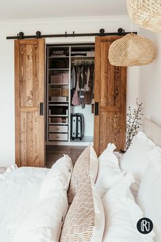 a bed with white pillows and wooden doors