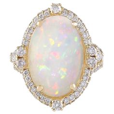 Introducing our exquisite 7.09 Carat Opal 14K Yellow Gold Diamond Ring, a stunning blend of luxury and elegance. 8.25 Carat Opal 14K Yellow Gold Diamond Ring Stamped: 14K Yellow Gold Total Ring Weight: 8 Grams Opal Weight is 6.80 Carat (Measures: 16.00x12.00 mm) Diamond Weight is 1.45 Carat Color: F-G, Clarity: VS2-SI1 Face Measures: 23.20x20.30 mm Sku: [704112W] Opal Diamond Ring, Cowry Shell, Yellow Gold Diamond Ring, Fine Jewelery, Zero Tolerance, Gold Diamond Ring, La Face, Opal Ring, Gold Diamond Rings