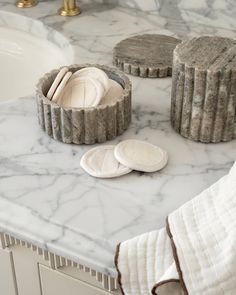 marble bathroom counter with soap and plates on it