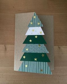 a card with a christmas tree made out of paper on top of a wooden table