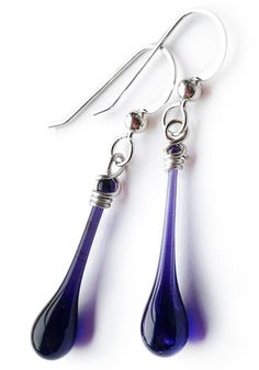 The deep, dark purple of these simple yet elegant glass earrings evoke the smooth flow of molten glass, frozen forever in an elegant drop of glass. Whether you’re running a few errands or dressing up for an evening, these deceptively simple glass earrings will add the finishing touch to any outfit. Earring length: 1 3/8" - 1 5/8" including hook Eco-friendly jewelry, made from a scrap of stained glass melted with focused sunshine Recycled sterling silver findings are nickel free and hypoallergeni Elegant Glass Drop Jewelry, Elegant Drop Glass Jewelry, Elegant Drop-shaped Glass Jewelry, Elegant Glass Teardrop Pendant Jewelry, Trio Necklace, Dainty Pendant Necklace, White Jewelry Box, Dainty Pendant, Spiral Earrings