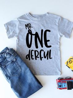 a t - shirt with the words mr onederal on it next to toy cars