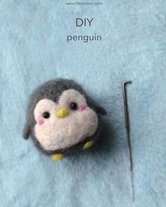 a needle is hooked up to a small penguin pincusher on a blue blanket