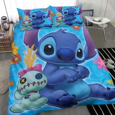 a bed with a blue comforter that has stitching on it and two cartoon characters