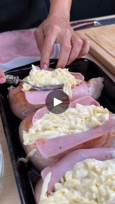 a person is spreading cheese on top of ham