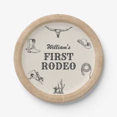 the first rodeo logo on a round wooden plate with an image of horses and cowboys