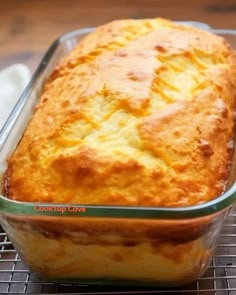 a loaf of bread sitting on top of a cooling rack next to a glass container