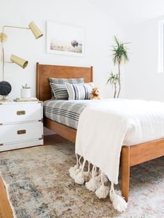 a bedroom with a bed, dresser and rug