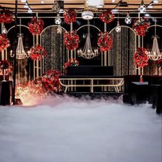 a room decorated for christmas with red decorations and chandeliers hanging from the ceiling