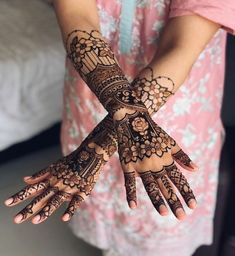 a woman's hands with hennap on her hand and the arm is decorated with intricate designs