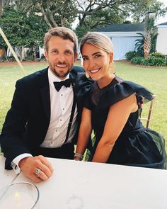 a man and woman are sitting at a table smiling for the camera while posing for a photo