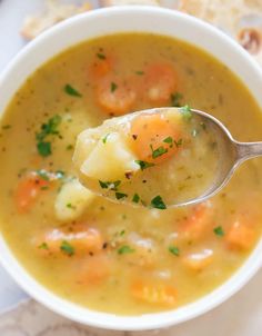 a spoon full of soup with potatoes and carrots