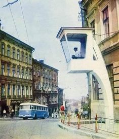 a blue bus driving down a street next to tall buildings and people walking on the sidewalk