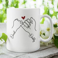 two hands holding each other with the words thank you in black ink on a white coffee mug