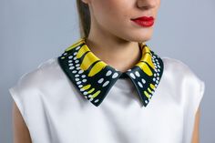 a woman wearing a yellow and black collar with polka dots on it's neck