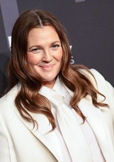 a woman in a white suit smiling at the camera