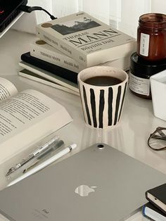 an apple laptop computer sitting on top of a desk next to a cup of coffee