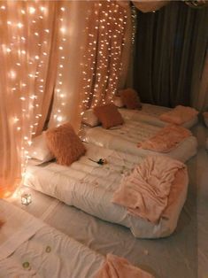 two beds covered in blankets with lights on them