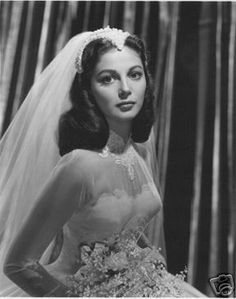 an old black and white photo of a woman in a wedding dress wearing a veil