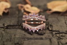 a close up of a ring on a piece of wood with leaves in the background