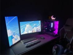 two computer monitors sitting on top of a desk next to a keyboard and monitor screen