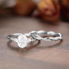 two engagement rings on a table with apples in the background