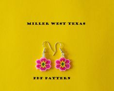 a pair of pink and yellow beaded earrings sitting on top of a yellow background