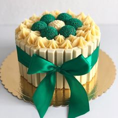 a cake decorated with green and white icing on top of a gold platter