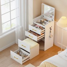 a white dresser with drawers and lights in a bedroom next to a lamp on the floor