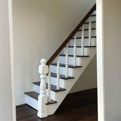 a white staircase with black steps and wooden handrails