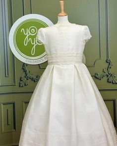 Margarita is an elegant and traditional first communion dress, it is made with off-white silk and has gorgeous lace details. The skirt is pleated and has details throughout. The appliqué is removable. The dress has covered buttons for closure, and strings to form a bow. Made in Spain Does not include crinoline Dry Clean Final sale, no exchanges nor returns are available Elegant A-line Confirmation Dress, Classic White Dress With Lace Bodice, Elegant Cream Lace First Communion Dress, Elegant White Dress For Confirmation, Elegant Lace Confirmation Dress, Elegant Cream First Communion Dress With Lace Bodice, Elegant Fitted Cream First Communion Dress, Elegant Cream First Communion Dress, Classic Dresses With Fitted Bodice For First Communion