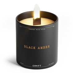 a black candle with an orange flame in it on a white background that reads, black amber cremet