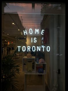 there is a neon sign in the window that says home is toronto on it's side