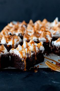 a chocolate cake with caramel drizzle and whipped cream on top is shown