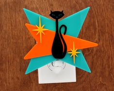 a black cat sitting on top of a light switch cover with stars and a star