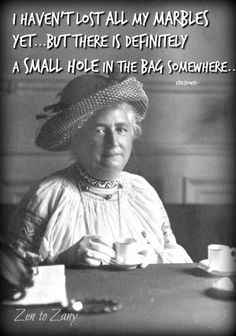 an old black and white photo of a woman sitting at a table holding a cup